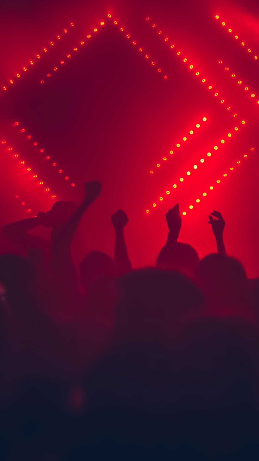 Crowd under red diamond LED lights at a venue