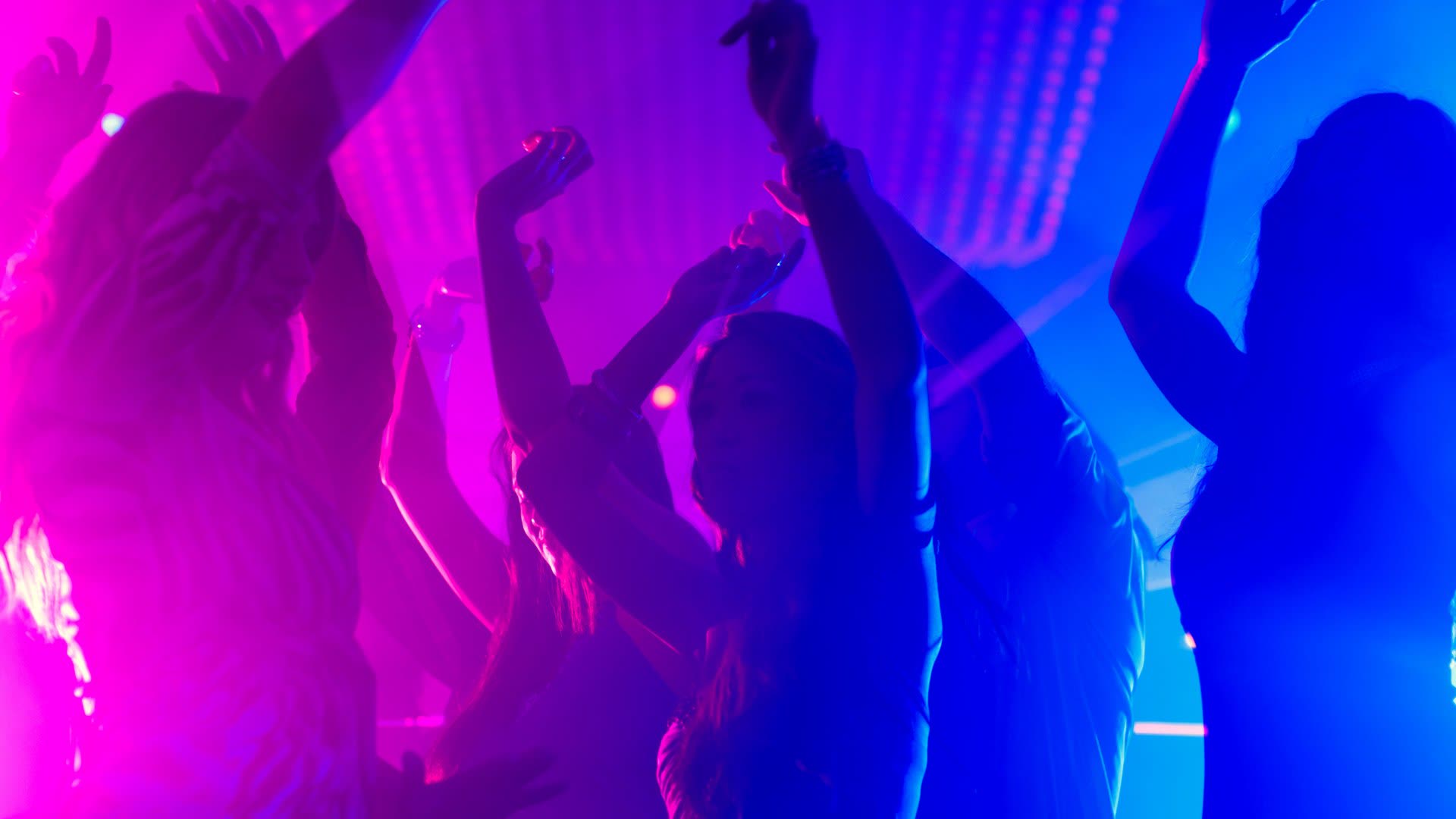 People dancing under neon pink and blue lights