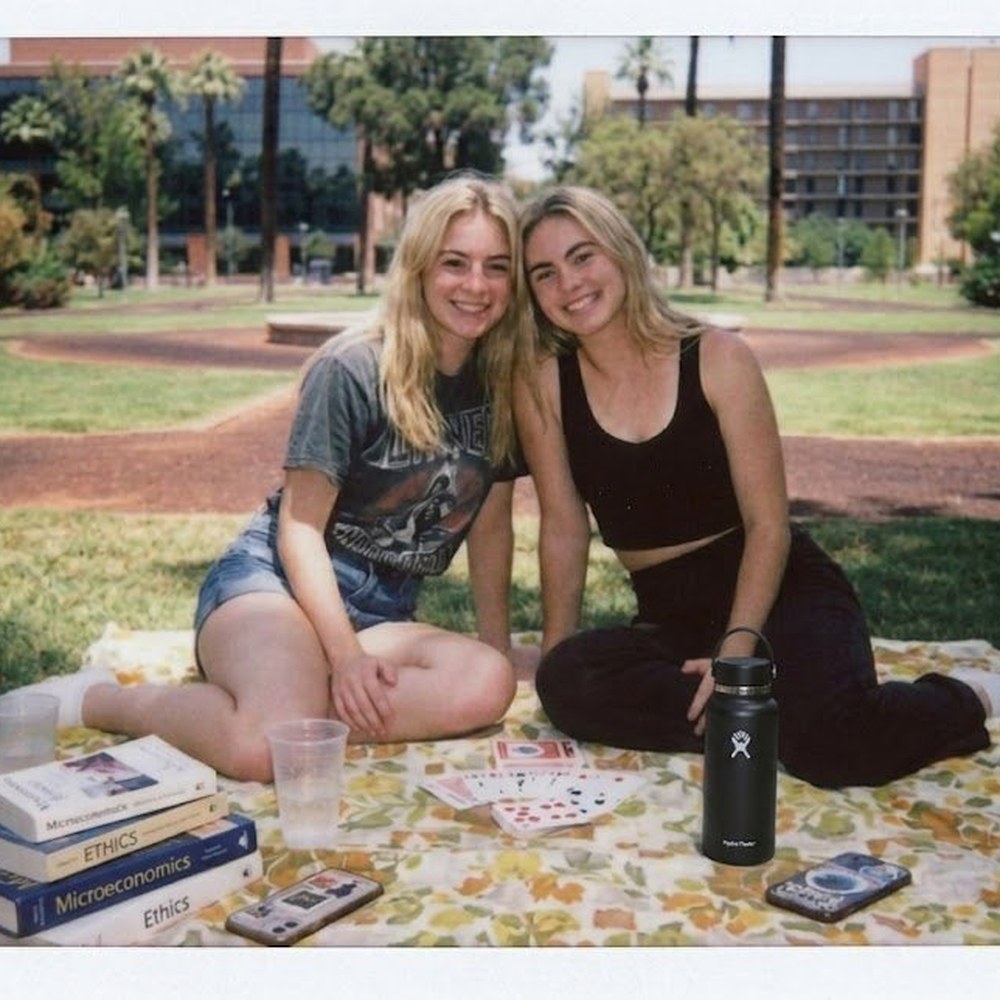 Two friends hanging out on a college quad